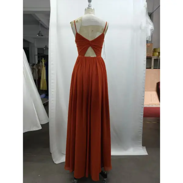 Detailed back view of Camille in Paprika Chiffon A-Line Dress highlighting the dramatic open back with signature twist detail, delicate criss-cross spaghetti straps, and softly gathered waist leading into the flowing pleated skirt.