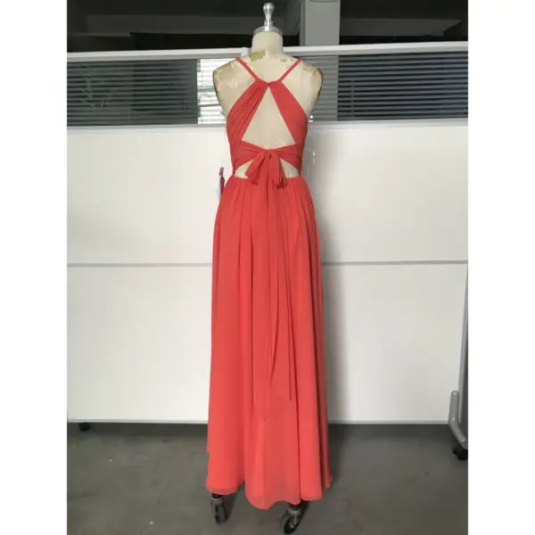 Back view of the Isolde Burnt Orange chiffon dress featuring intricate criss-cross straps, open back design with elegant bow detail at the waist, and flowing skirt with high slit for graceful movement.