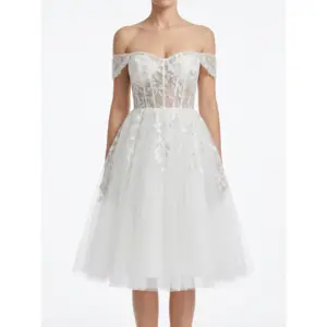 Front view of the Marie Ivory bridal gown featuring delicate embroidered leaf motifs on luxurious tulle fabric, romantic off-the-shoulder sweetheart neckline with illusion tulle straps, and a full layered tulle skirt that creates ethereal bridal romance.