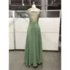 Back view of the Elowen Fern Chiffon Lace Applique A-Line Gown showcasing intricate green lace appliques, deep open back with crisscross straps, lace-up corset tie closure, and elegant flowing chiffon fabric.