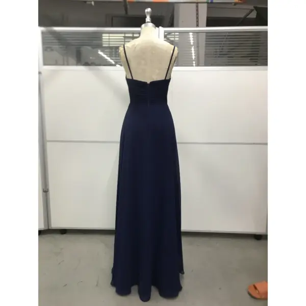 Back view of Evelina Navy Chiffon Gown featuring a sleek ruched bodice, delicate spaghetti straps, concealed zipper closure, and graceful floor-length A-line skirt in luxurious flowing fabric.