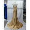 Back view of the Flavia Golden Stretch Satin Mermaid Gown showcasing a corset-style lace-up back with zipper closure, ruched detailing at the hips, and the full sweeping train of the opulent golden stretch satin fabric.