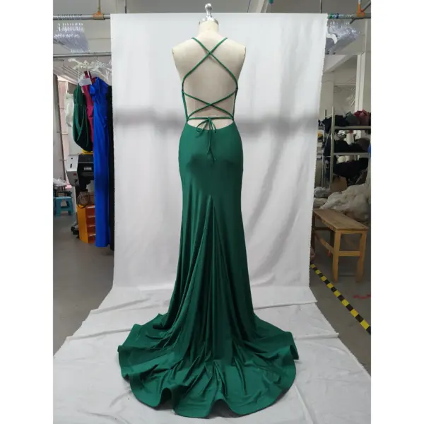 Back view of the Louise teal jersey mermaid gown showcasing intricate crisscross strap detailing, open back design with tie closure, fitted through the hips with a central zipper and flowing dramatic train.