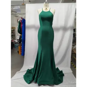 Stunning teal jersey mermaid gown on a mannequin featuring a sleek halter neckline with thin spaghetti straps, figure-hugging silhouette that flares into a dramatic sweep train, luxurious fabric with beautiful drape and subtle sheen.