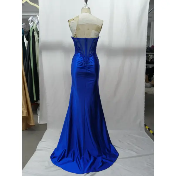 Back view of the Allison royal blue mermaid gown showcasing illusion lace applique panels with rhinestone embellishments, a central zipper closure, ruched detailing, and a sweeping train in luxurious stretch satin.