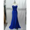 Stunning royal blue stretch satin mermaid gown featuring a strapless sweetheart neckline adorned with intricate rhinestone-embellished blue lace appliques, ruched bodice, and a figure-hugging silhouette with a side slit.