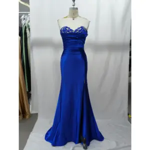 Stunning royal blue stretch satin mermaid gown featuring a strapless sweetheart neckline adorned with intricate rhinestone-embellished blue lace appliques, ruched bodice, and a figure-hugging silhouette with a side slit.