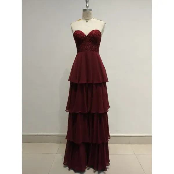 Stunning Elizabeth Burgundy tiered chiffon ball gown featuring a sweetheart neckline, intricate lace appliques with rhinestones on the bodice, and cascading layered chiffon skirt in rich burgundy hue.