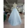 Back view of the Zoé Baby Blue tulle ball gown showcasing a romantic corset lace-up back with delicate embroidery and appliques, flowing into a voluminous tiered sparkling tulle skirt.