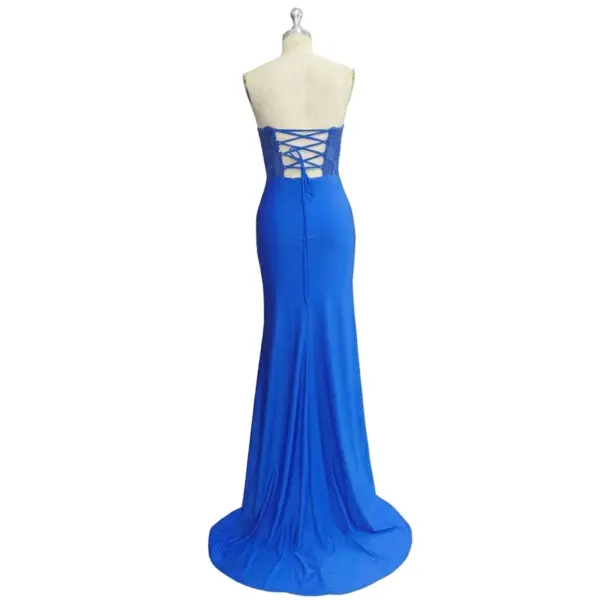 Elegant back view of the Victoire Royal Blue jersey mermaid dress showcasing delicate lace-up corset closure, sheer embroidered applique panel, and flowing sweep train that creates a sophisticated old money silhouette.