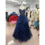 Front view of Kallista Sparkle Tulle Embroidered Applique Gown in rich navy featuring a sweetheart neckline, intricate sequin and embroidery bodice with delicate lace appliqués, and cascading layered sparkle tulle skirt with dramatic ruffles