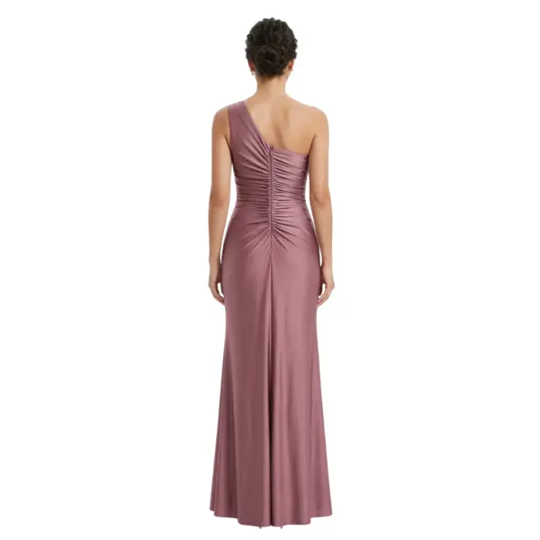 Back view of the Vivienne Grape One-Shoulder Ruched Jersey Gown featuring a sleek one-shoulder design, intricate ruching across the back with a central zipper closure, and a smooth floor-length skirt with subtle train. The rich grape jersey fabric drapes beautifully for an elegant silhouette.
