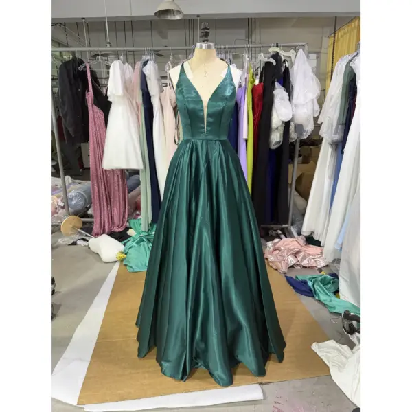 Stunning Clelia in rich Forest green Polyester Satin, featuring a plunging V-neckline, fitted bodice, and dramatic full ball gown skirt with natural volume and luxurious sheen. The deep emerald tone and silky fabric create a show-stopping prom silhouette with practical side pockets.
