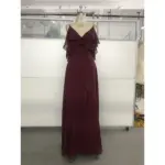 Elegant Capucine gown in rich Wine color featuring flowing Chiffon fabric, a deep V-neckline with cascading ruffles on the shoulders, and a sophisticated high slit that reveals graceful movement.