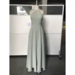 Front view of the Simone Sage Green Chiffon Halter A-Line Gown featuring a pleated halter neckline, ruched bodice at the waist, and flowing floor-length A-line skirt in luxurious sage green chiffon fabric.