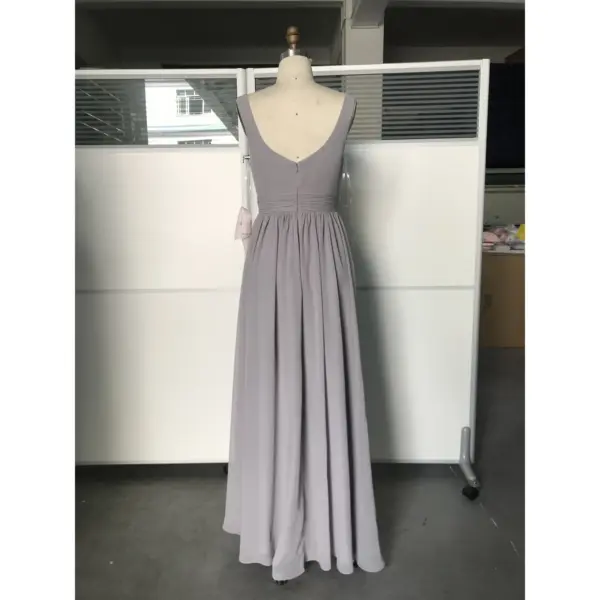 Back view of the Jolanda Silver Chiffon gown showcasing a deep V-back, concealed zipper closure, and softly pleated waist detail that transitions into a graceful floor-length A-line skirt in shimmering silver chiffon.