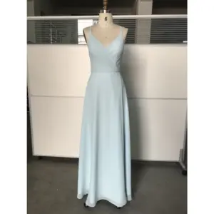 Elegant Megan in flowing Sky Blue Chiffon fabric featuring a flattering V-neckline, spaghetti straps, and a subtle high slit that adds graceful movement to this floor-length A-line dress.