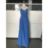 Ocean Blue chiffon gown with V-neckline, delicate spaghetti straps, ruched waist detailing, side ruffles, and high slit on a mannequin