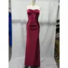 Stunning strapless sweetheart neckline Burgundy stretch satin mermaid gown by Alex featuring ruched bodice, internal boning, and dramatic high slit on a mannequin in a studio setting