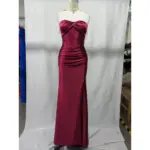 Stunning strapless sweetheart neckline Burgundy stretch satin mermaid gown by Alex featuring ruched bodice, internal boning, and dramatic high slit on a mannequin in a studio setting