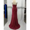 Back view of the Tina burgundy mermaid gown showcasing a corset-style lace-up back with zipper closure, ruched detailing through the hips, and a flowing sweep train in luxurious jersey fabric.